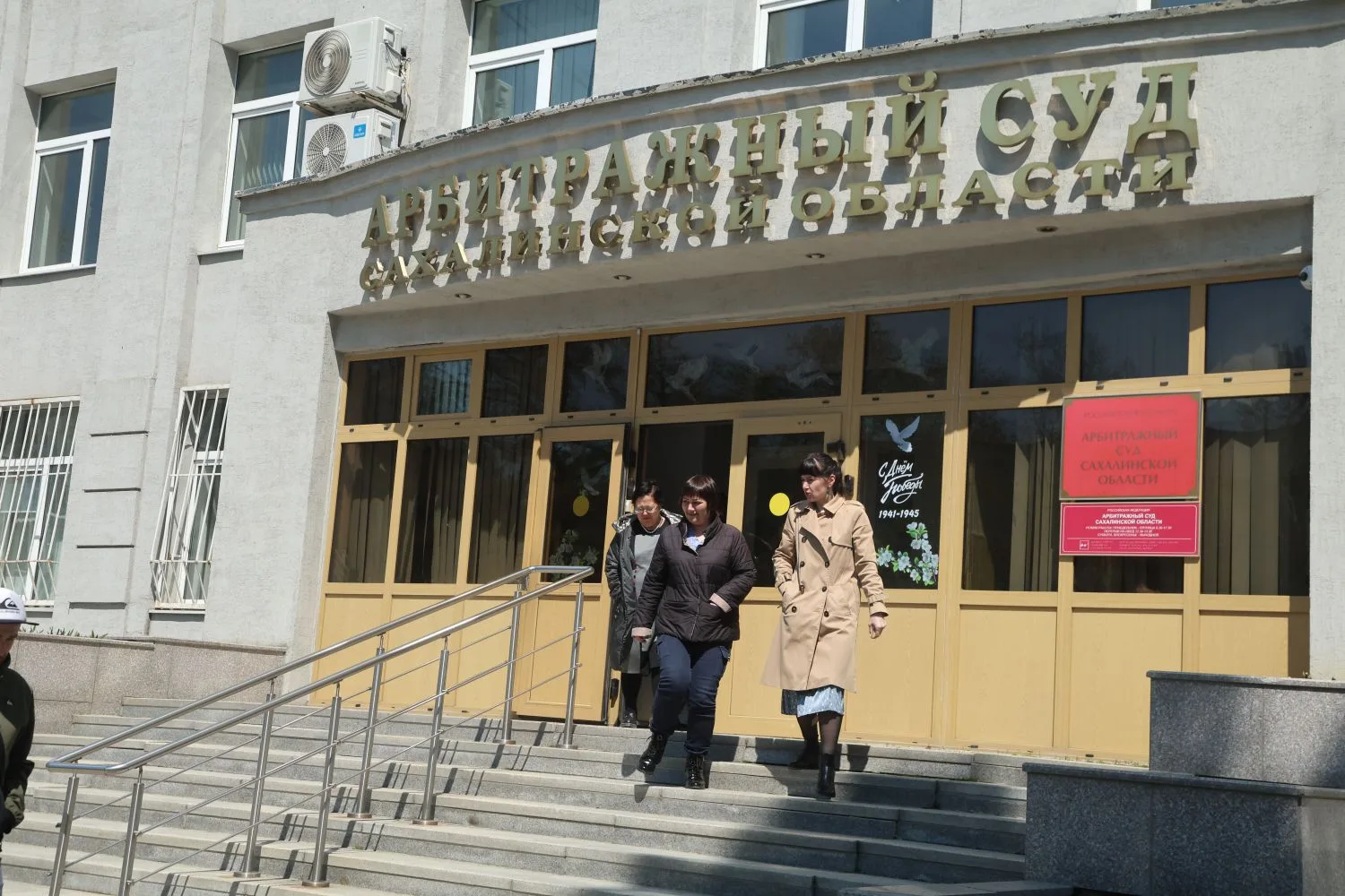 На фото изображен суд и сотрудники, покидающие его при пожарной тревоге.